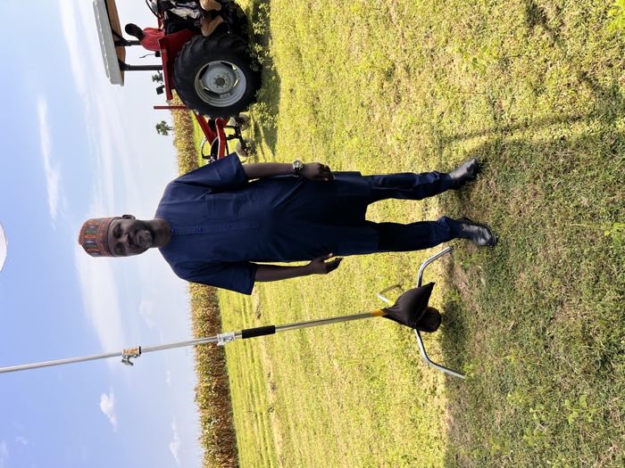 Adani Abdallah standing on a farm with a tractor behind